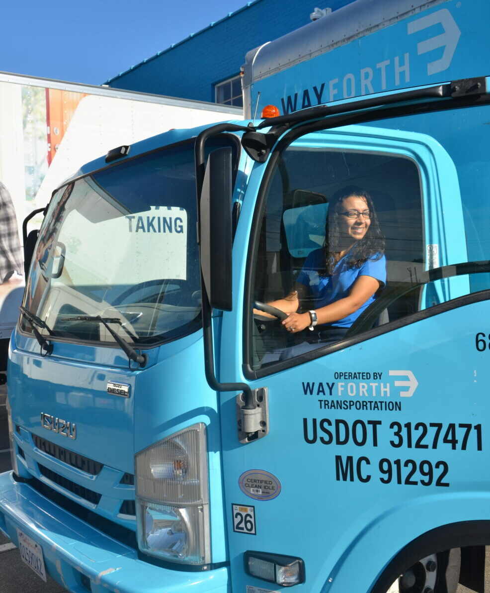 a smiling Wayforth mover driving a Wayforth moving truck